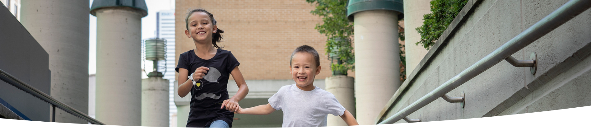 Children run holding hands outside SickKids